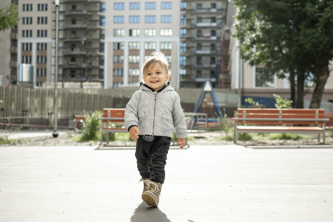 a-kid-walks-on-a-children-s-playground-in-the-courtyard-of-an-apartment-building.jpg