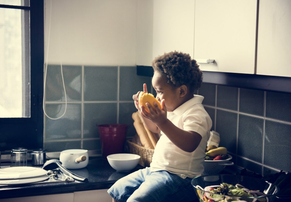 black-kid-with-orange-in-the-kitchen.jpg