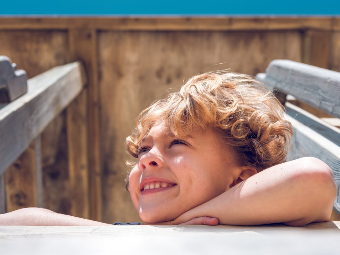 cheerful-child-smiling-on-wooden-castle-playground.jpg