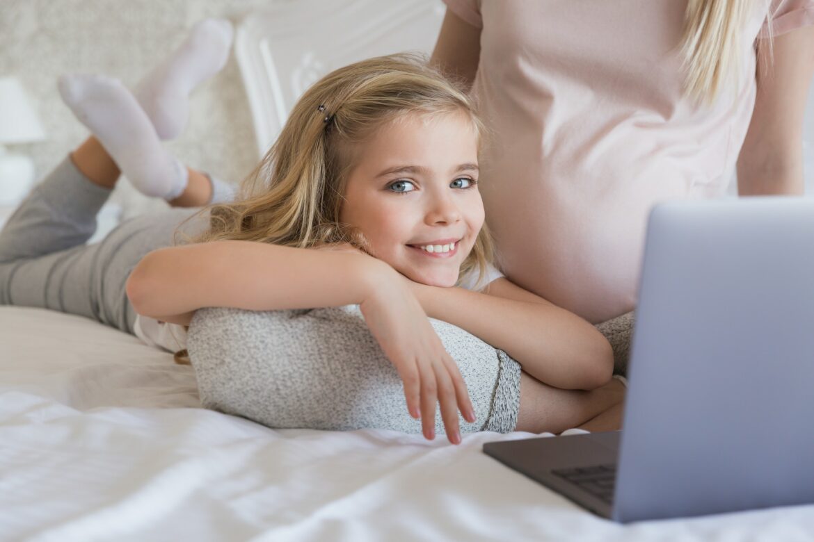 cropped-image-of-smiling-kid-lying-on-mothers-leg.jpg