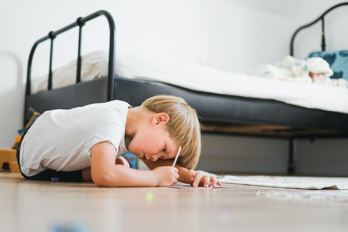 cute-blonde-boy-in-white-t-shirt-draws-on-floor-in-the-children-room.jpg