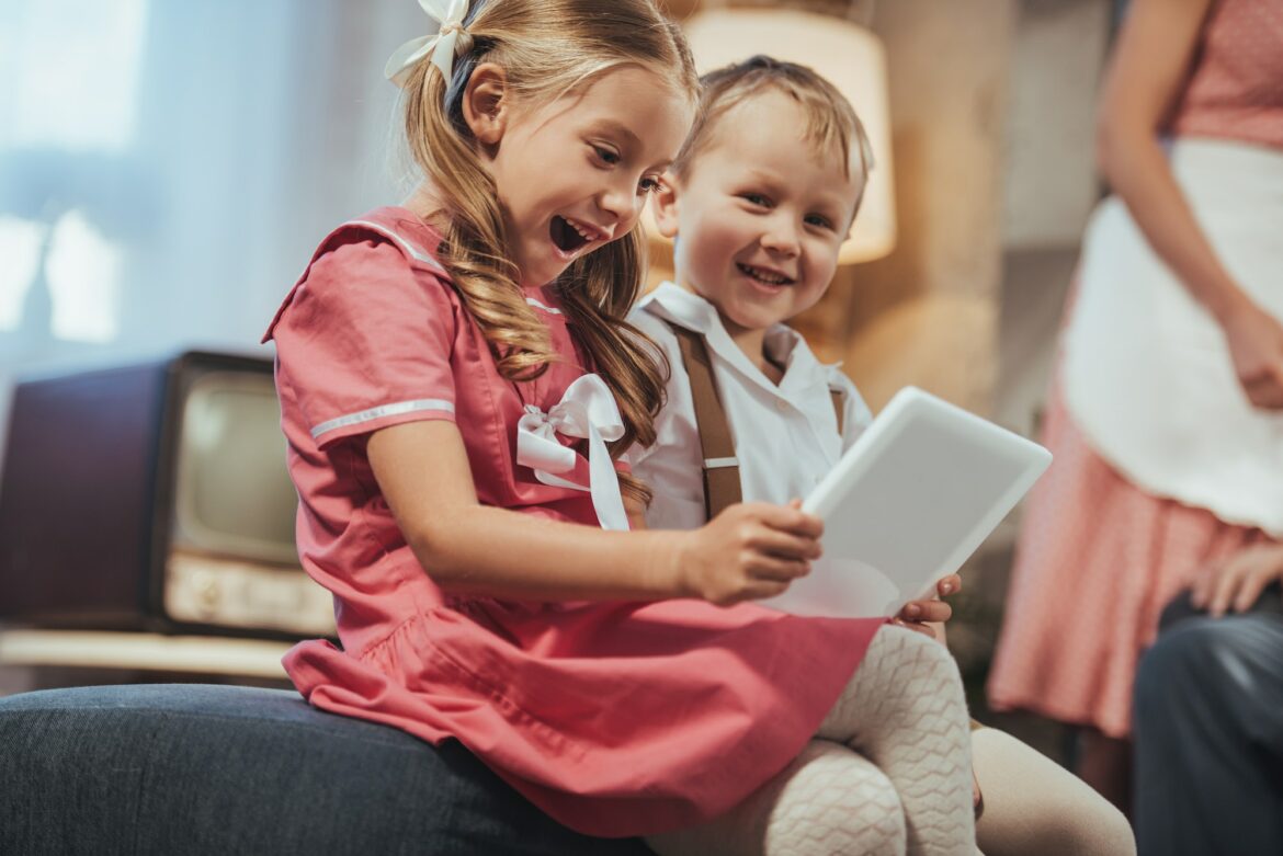 excited-little-kids-in-1950s-style-clothes-using-digital-tablet-at-home.jpg