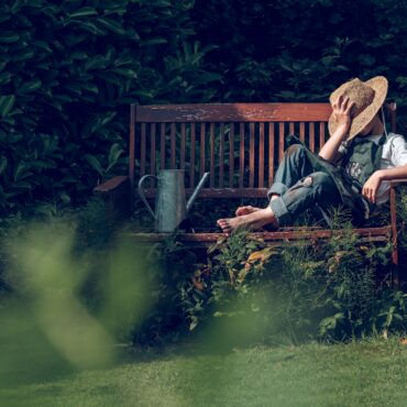 Gardener kid resting on bench after work