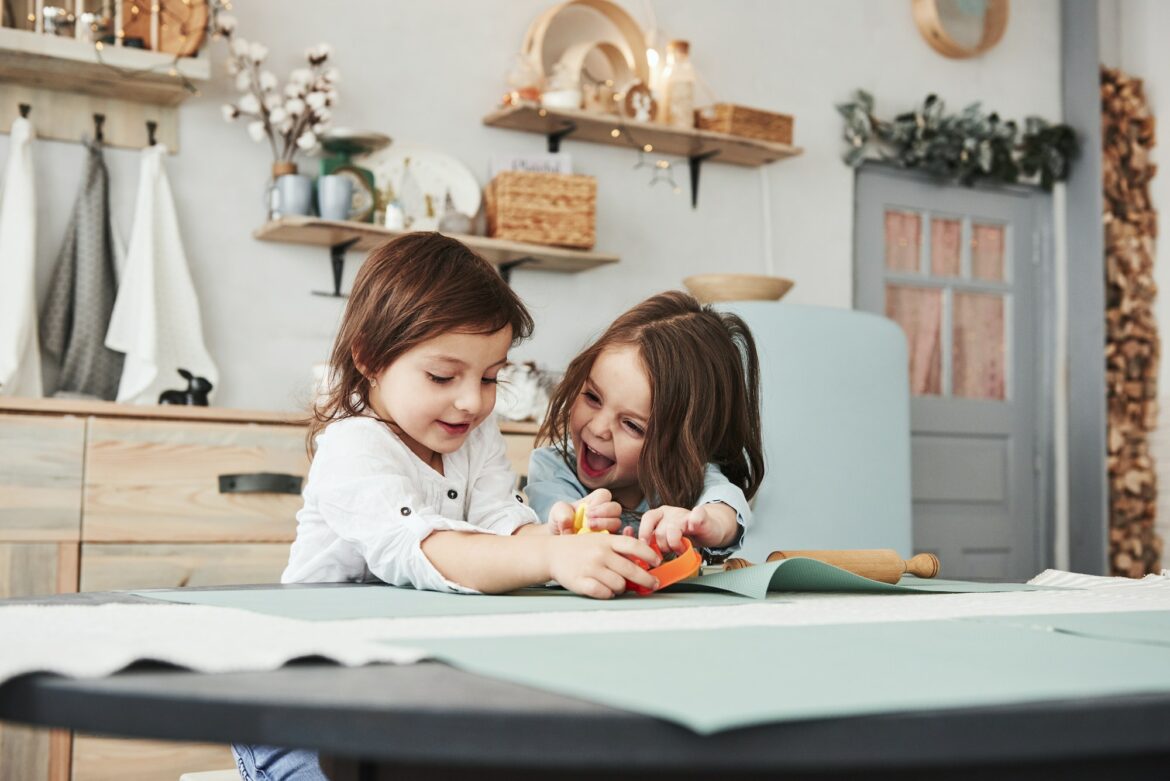 happy-childhood-two-kids-playing-with-yellow-and-orange-toys-in-the-white-kitchen.jpg