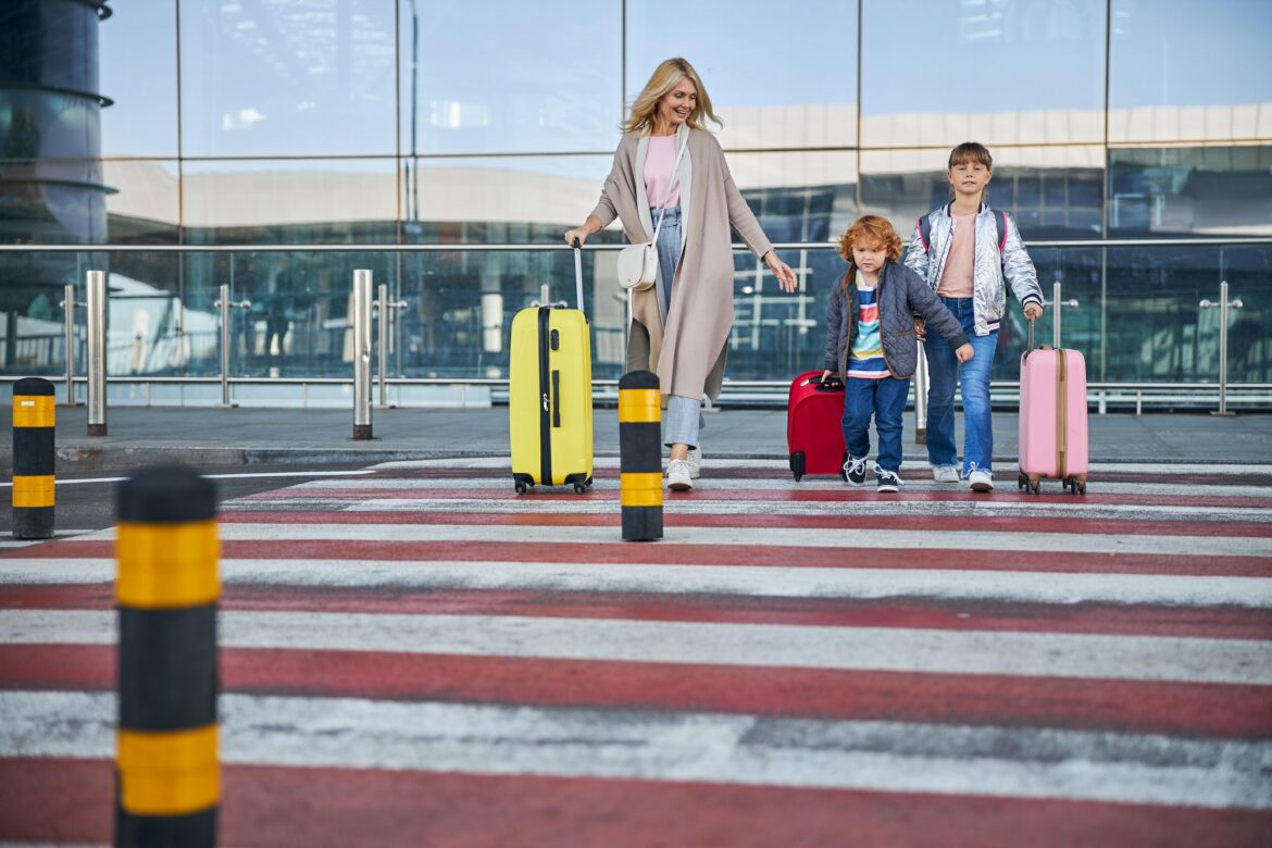 joyful-woman-coming-across-the-road-with-kids-and-luggage.jpg