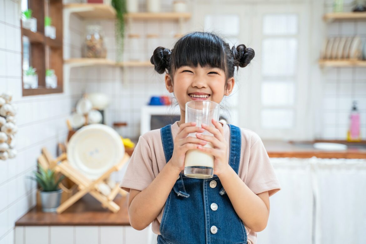 portrait-of-asian-little-cute-kid-holding-a-cup-of-milk-in-kitchen-in-house-and-look-at-camera.jpg