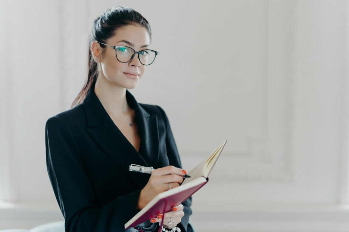 serious-elegant-female-teacher-in-black-formal-suit-plans-her-working-schedule.jpg