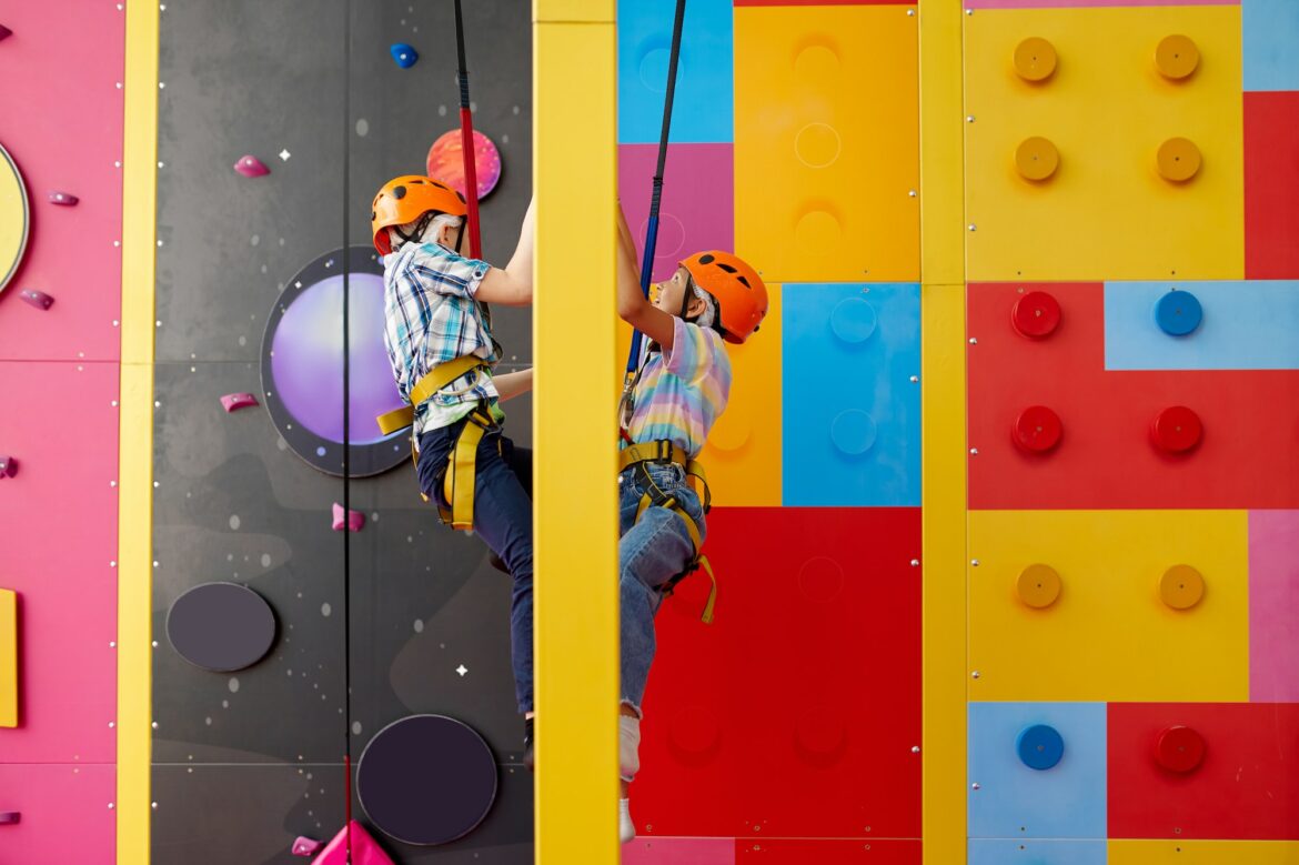 two-children-in-helmets-climb-on-climbing-wall.jpg