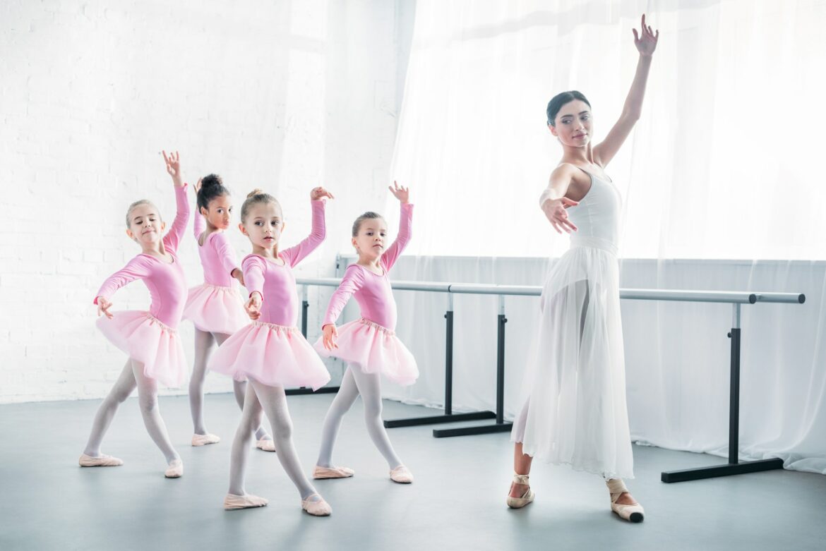 young-teacher-practicing-ballet-with-adorable-kids-in-pink-tutu-skirts.jpg