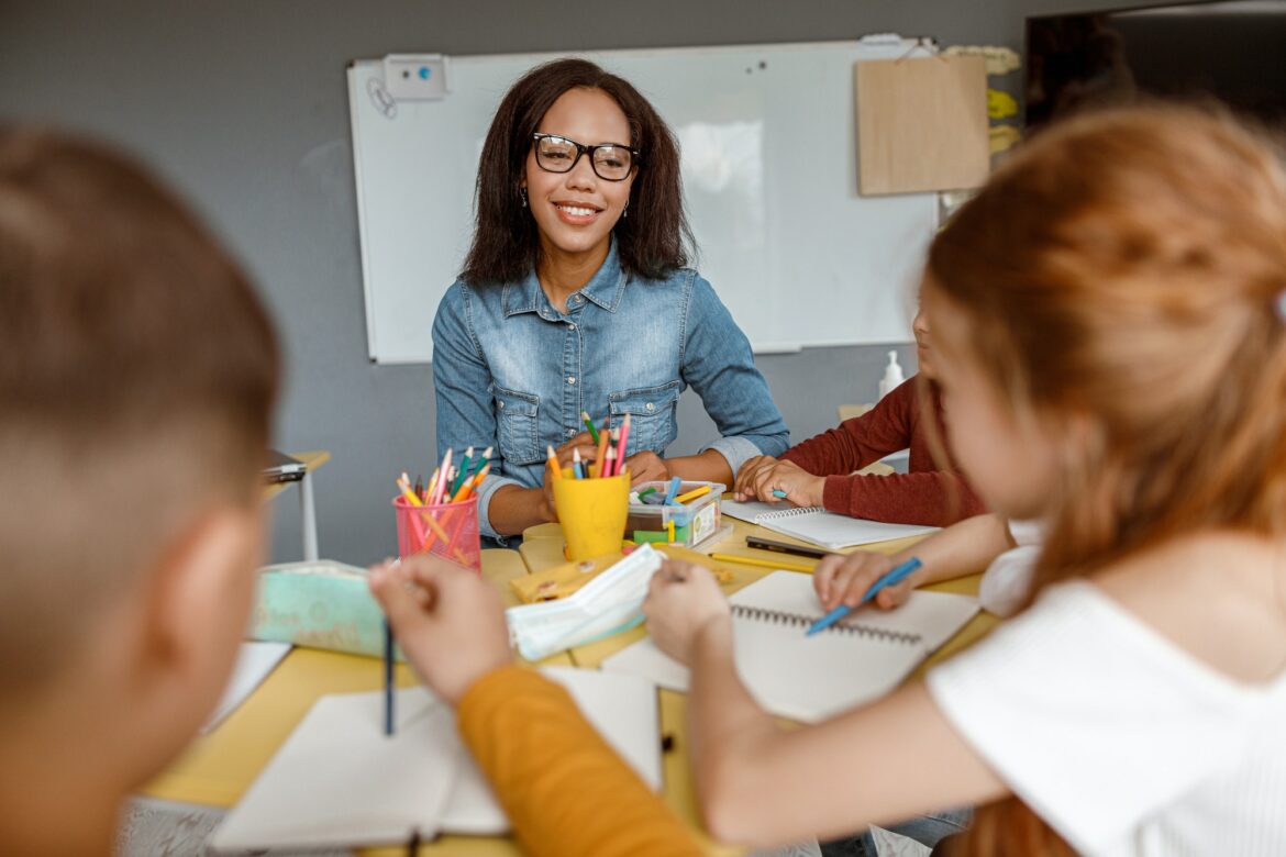 young-teacher-talking-with-kids-during-the-lesson-in-the-classroom.jpg